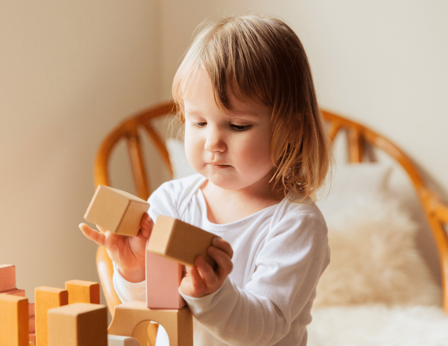 Toddler playing with wooden blocks in a cozy room