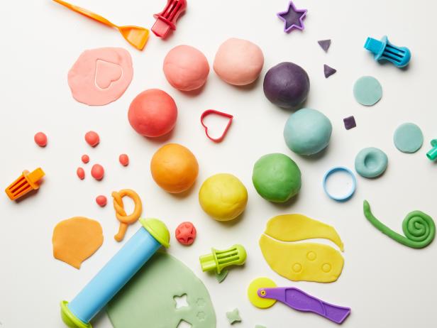 Colorful playdough set with cutters and rolling pin on white background
