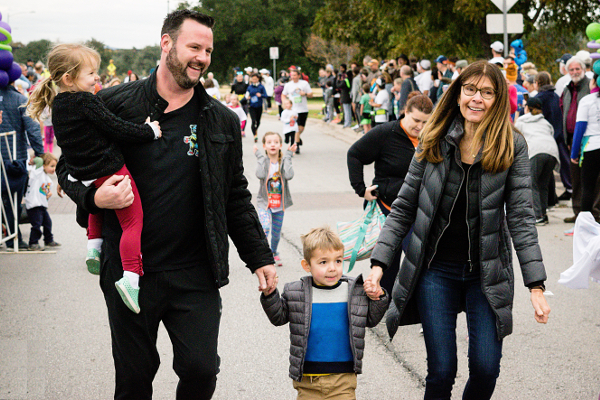 Preschooler walking with family in the 2018 Turkey Trot Preschooler walking with family in the 2018 Turkey Trot