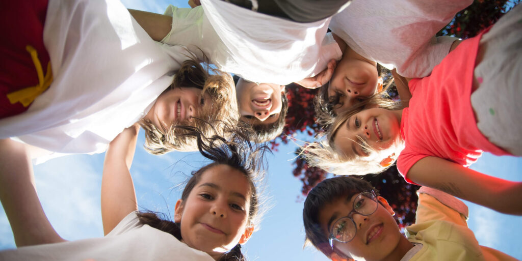 Group of happy children huddling outside on a sunny day