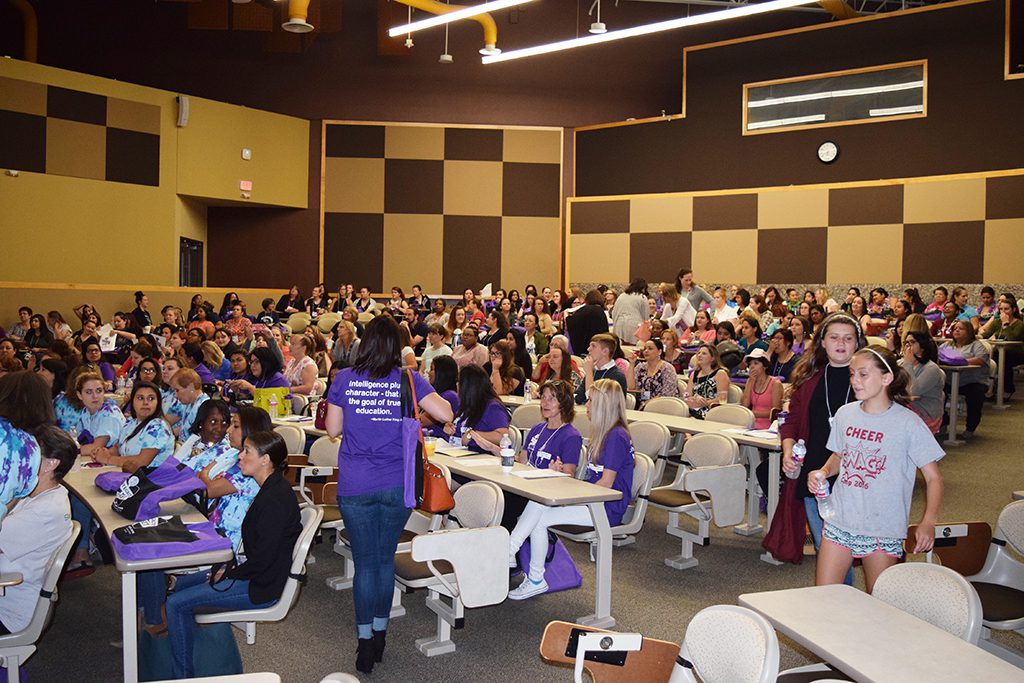 Large group of people seated in a lecture hall attentively listening to a presentation
