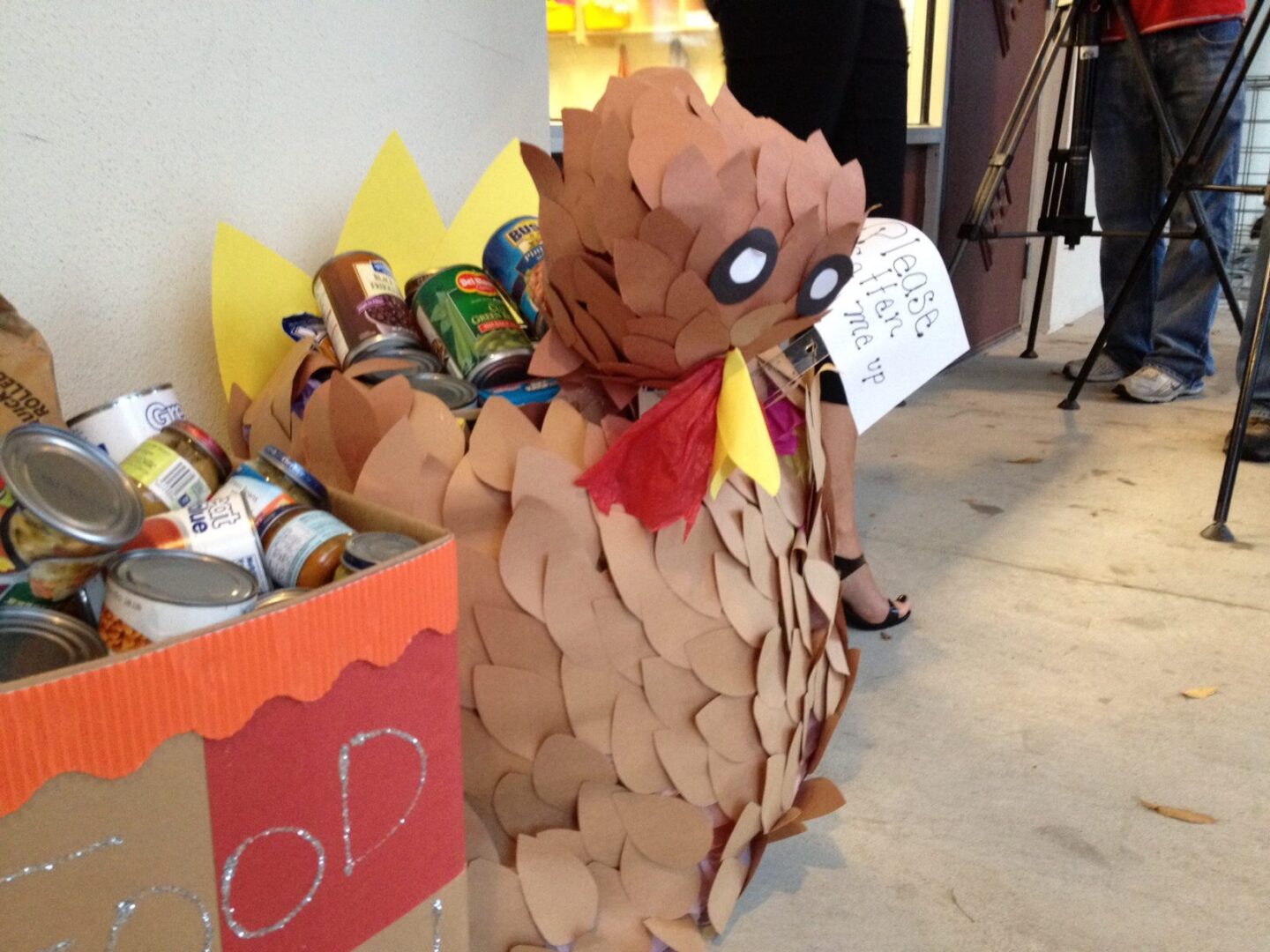 Thanksgiving food drive box decorated as a turkey filled with canned goods.