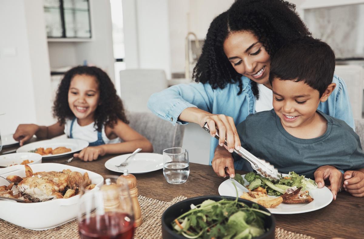 Family enjoying dinner together at home around a table with fresh food and smiles