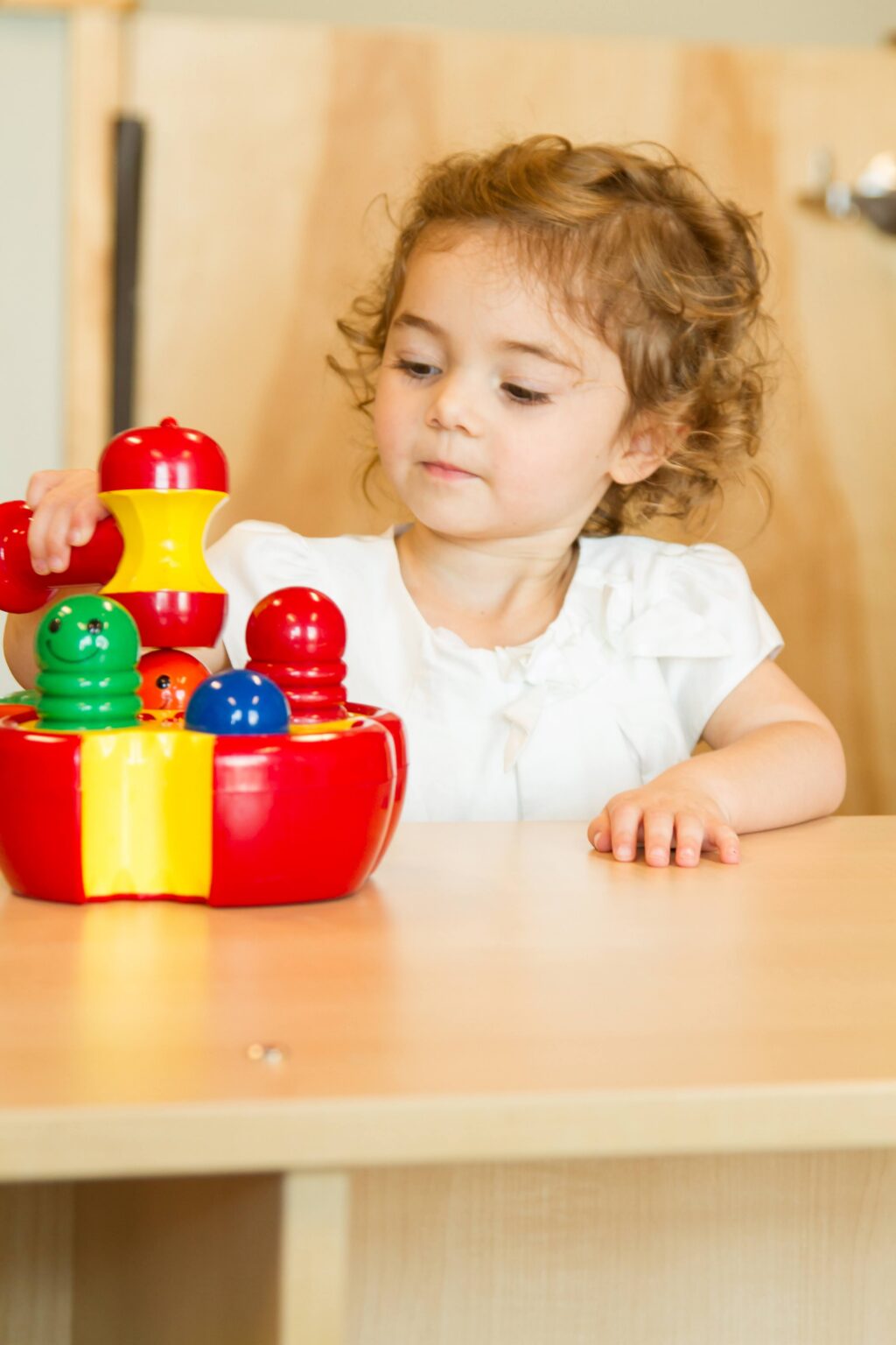 Toddler playing with colorful toy at a table