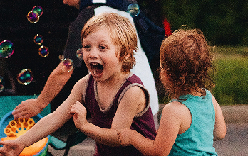 Children joyfully playing with bubbles outdoors