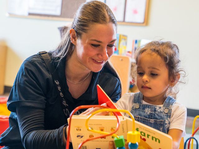 Teacher and child engaging in a fun learning activity together