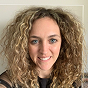 Woman with curly hair smiling at the camera