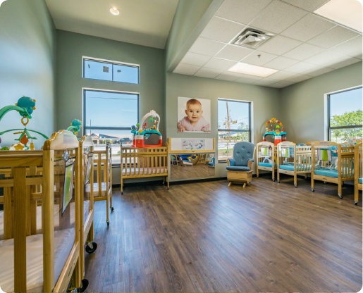 Bright daycare room with wooden cribs and colorful toys