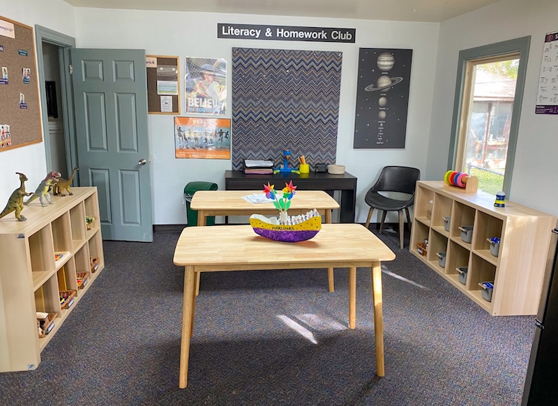 Classroom with wooden tables and educational displays at Literacy and Homework Club