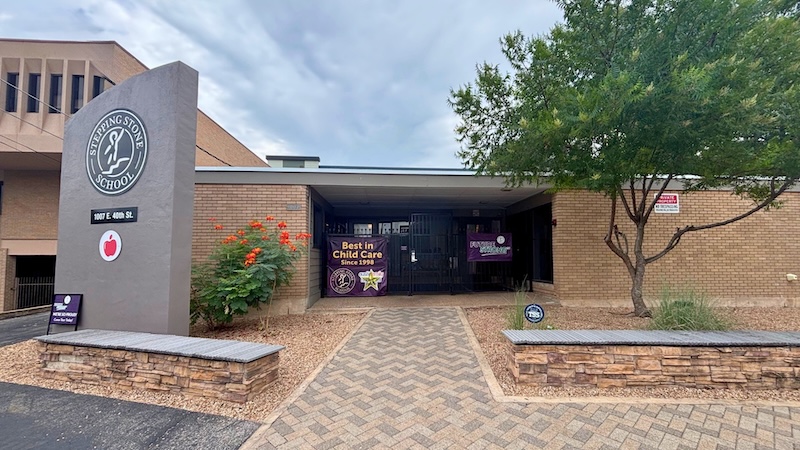 School entrance with signage Best in Child Care colorful plants and paved walkway