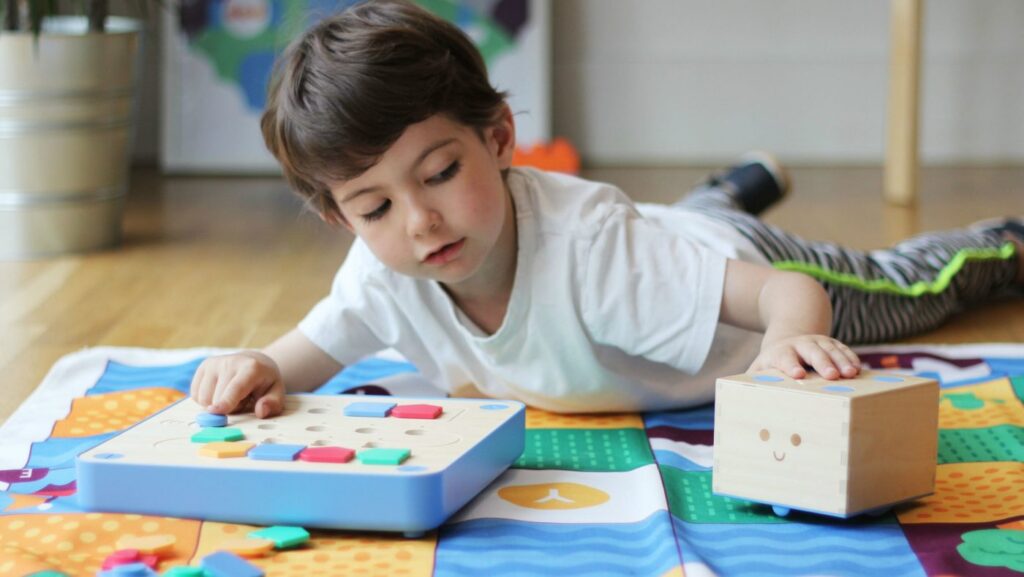 Child playing with educational toys on colorful mat