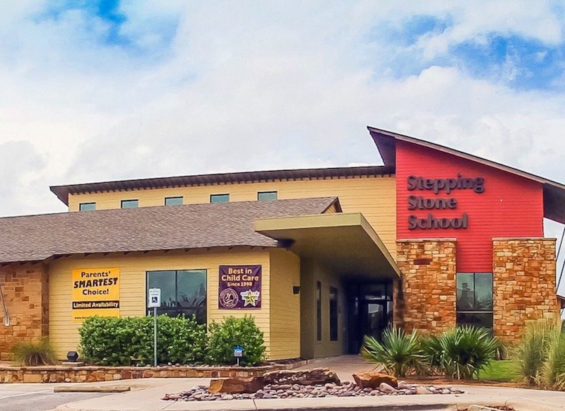 Front view of Stepping Stone School building with colorful signs and a clear blue sky