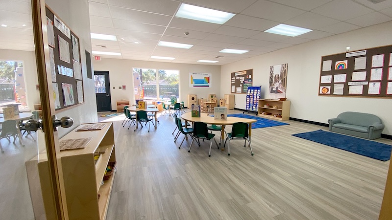Bright and spacious kindergarten classroom with tables and colorful decorations
