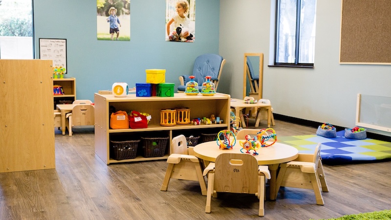 Bright and organized preschool classroom with toys and small furniture