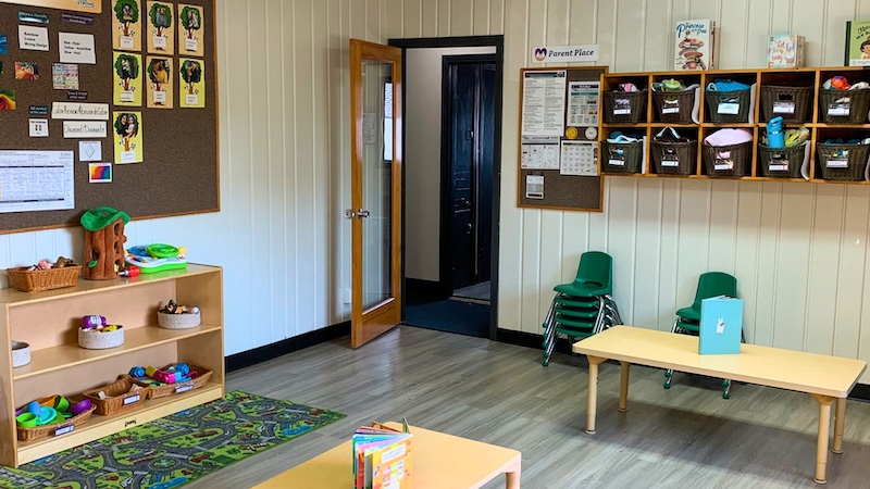 Bright and organized preschool classroom with toys and bulletin board