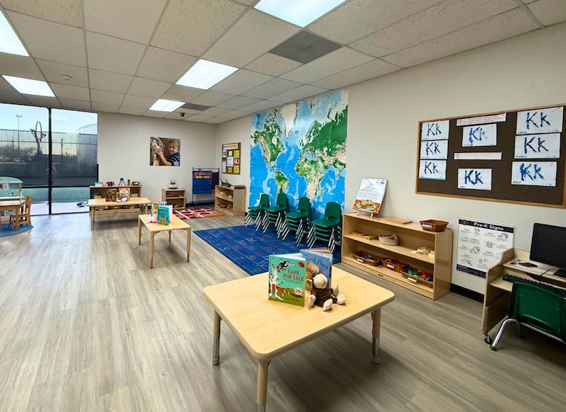 Bright preschool classroom with world map and colorful learning materials.