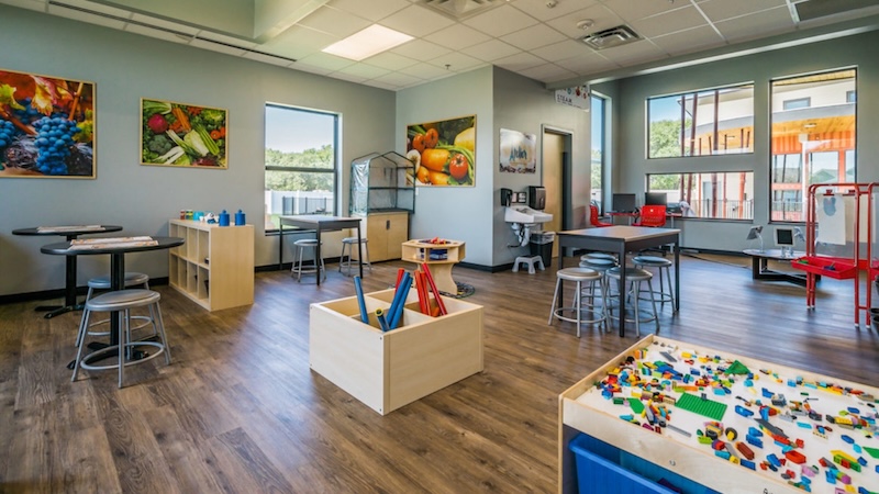 Bright classroom with educational toys and colorful decor, large windows letting in natural light