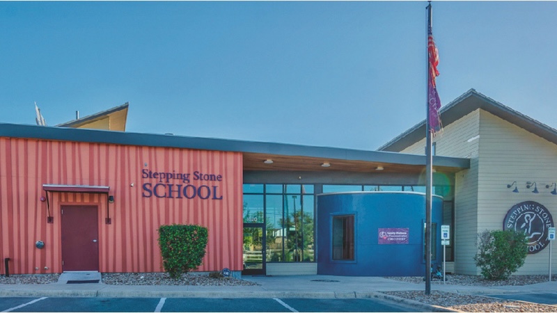 Colorful modern building exterior of Stepping Stone School under a clear blue sky