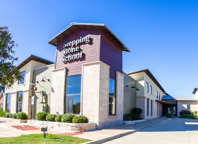 Modern building exterior of Stepping Stone School under a clear blue sky