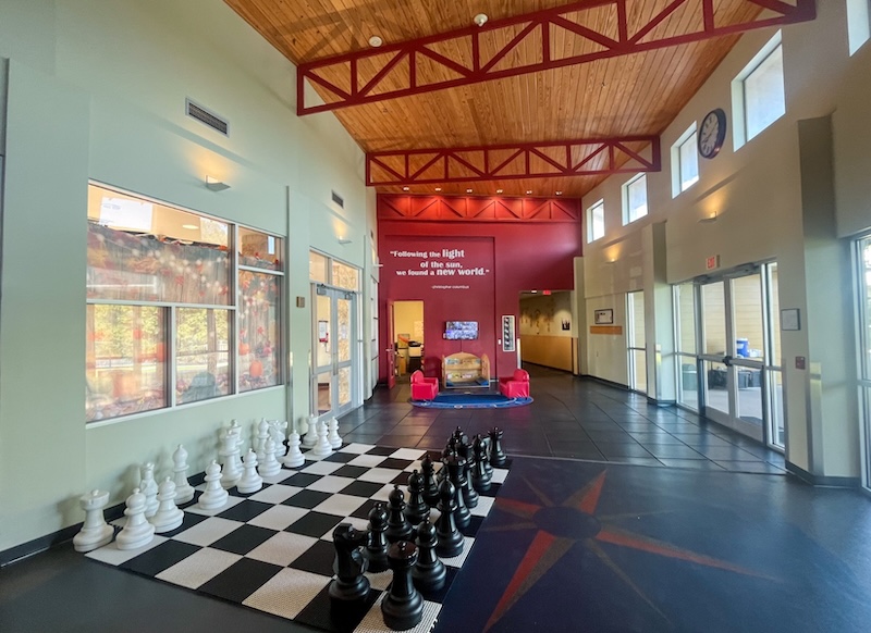 Large indoor chess set in a spacious room with high ceilings and natural light.