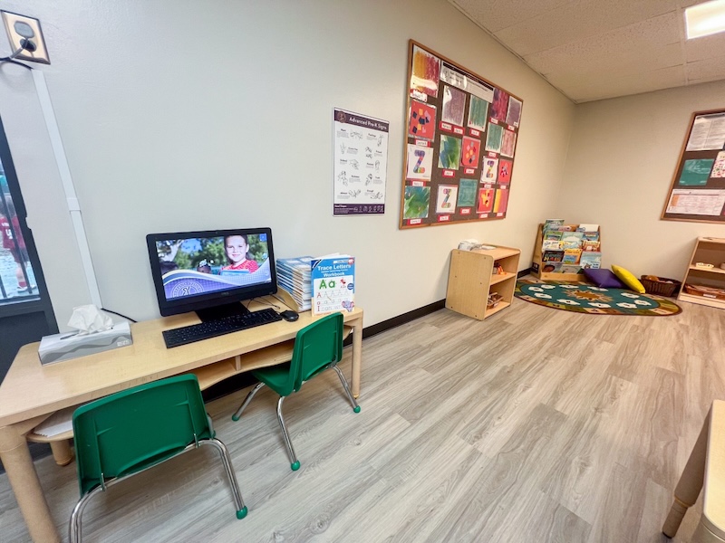 Preschool classroom with learning materials computer desk colorful wall art and reading corner