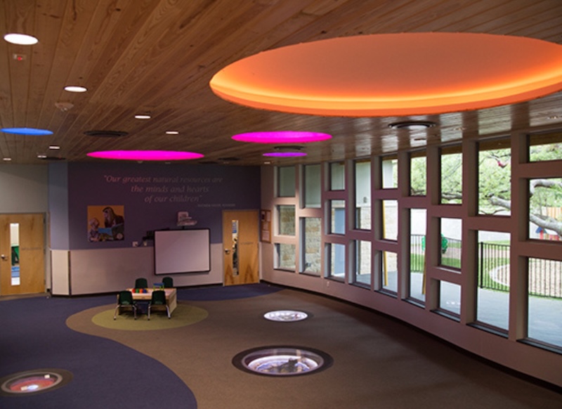 Modern classroom with colorful ceiling lights and large windows for natural light