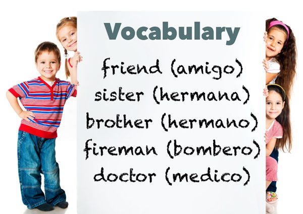 Kids holding a vocabulary poster with English and Spanish words